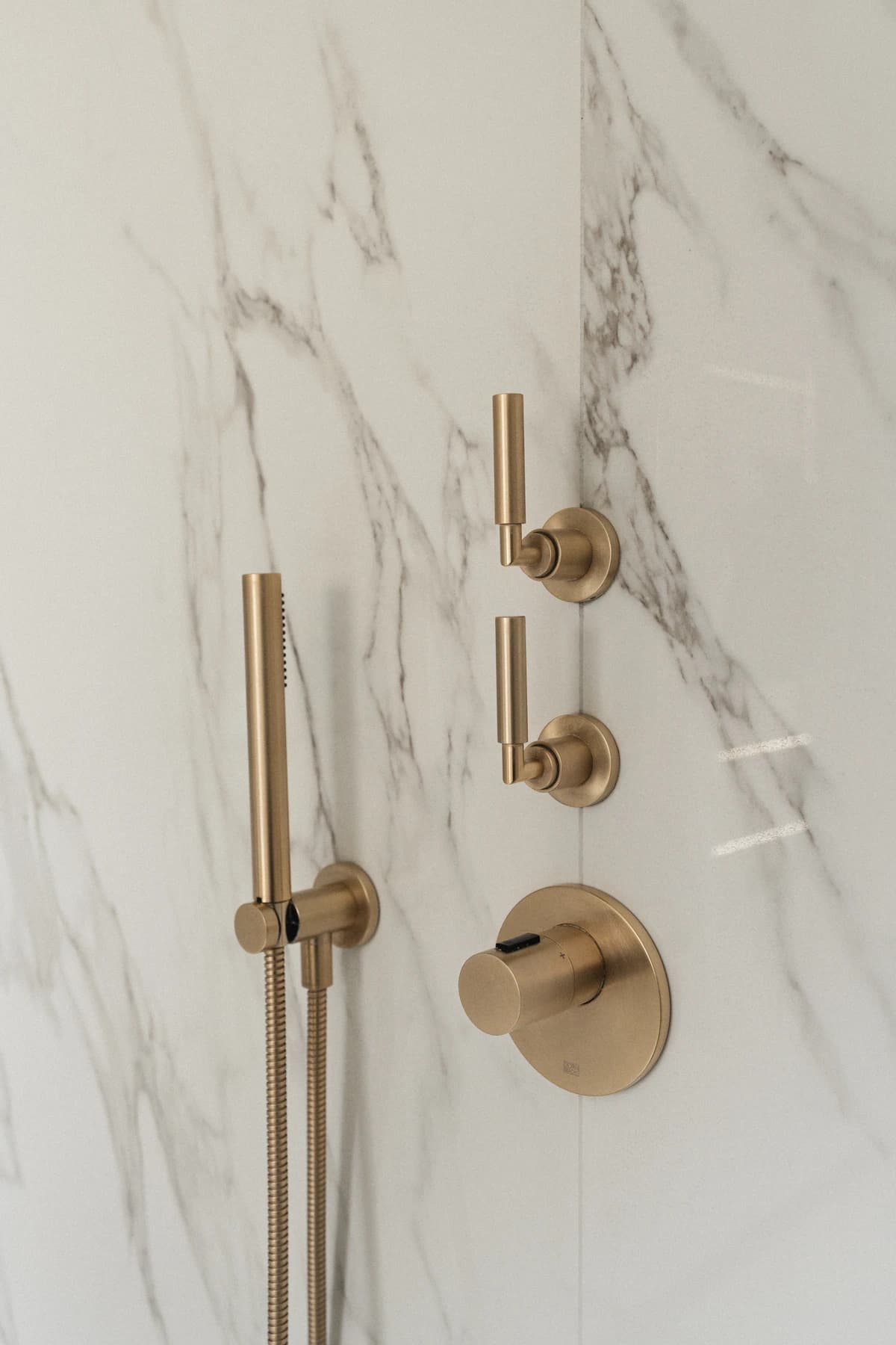 Badeværelser – badeværelse i marmor og kalksten med messing armatur · specialdesignet inventar fra snedker · Aalborg · Riise Studio